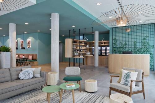 a lobby with a couch and chairs and tables at Residence Inn by Marriott Hamburg Altona in Hamburg