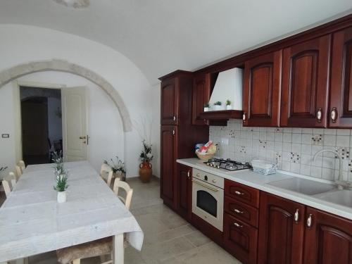 a kitchen with wooden cabinets and a white counter top at Trulli della Catena in Martina Franca