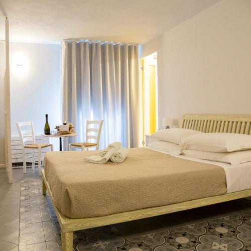 a bedroom with a bed and a table and chairs at PORTA SOPRANA luxury guest House & spa in Sclafani