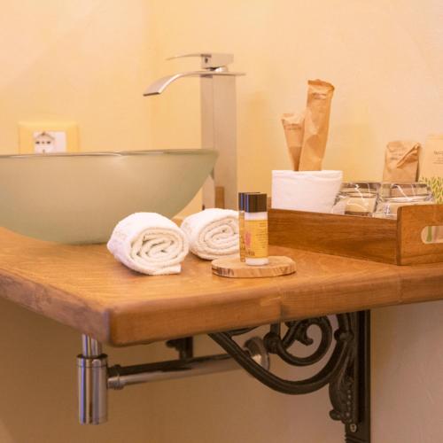 a bathroom with a counter with a sink and a sink at PORTA SOPRANA luxury guest House & spa in Sclafani
