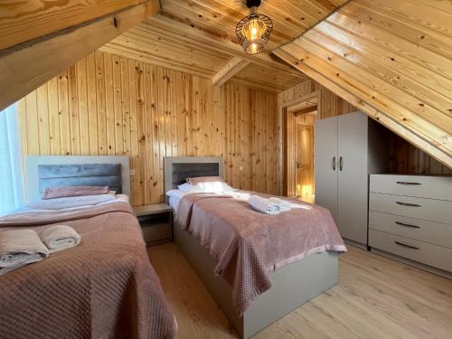 Duas camas num quarto com paredes de madeira em ,,Cottage for rent in GODERDZI'' em Khulo
