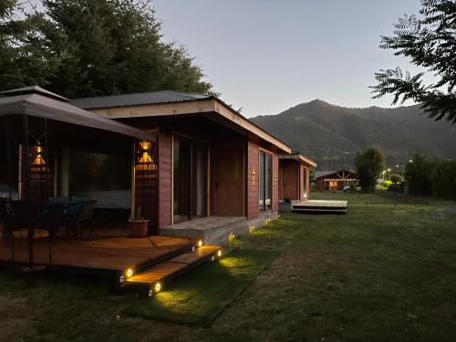a small house with lights in the yard at Comodidad y hermosa Vista Volcán in Melipeuco