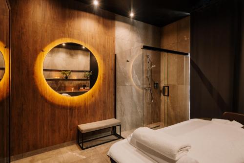 a bedroom with a bed and a mirror and a shower at Hotel Saltic Resort & Spa Grzybowo in Kołobrzeg