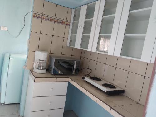 San Lucas SacatepéquezにあるHabitación con cocina - Hacienda Santo Domingoの小さなキッチン(電子レンジ、コンロ付)