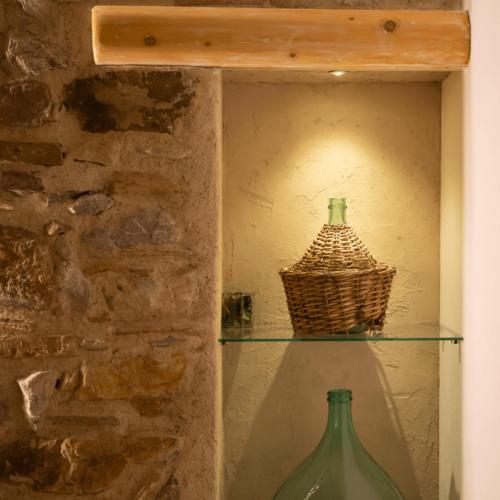 a shelf with two glass bottles and a basket at PORTA SOPRANA luxury guest House & spa in Sclafani