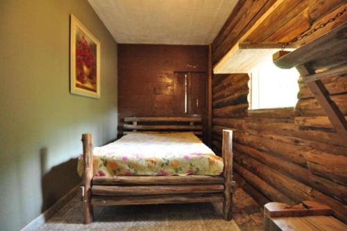 a bedroom with a bed in a log cabin at Chácara Spring Feston in Mairinque