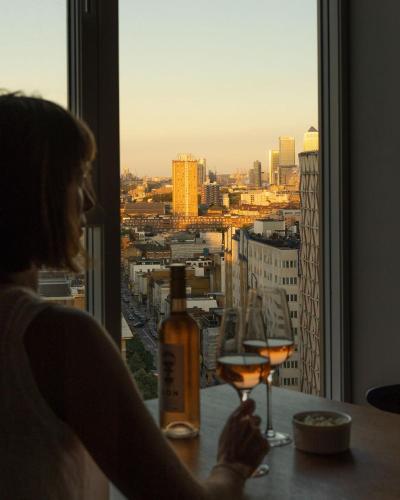 a woman sitting at a table with two glasses of wine at The Gate London City in London