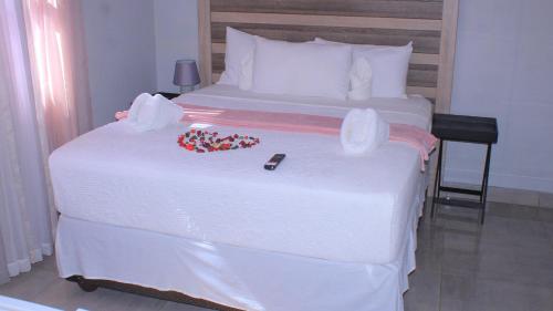 a bedroom with a white bed with candy on it at Serene Cottage in Francistown