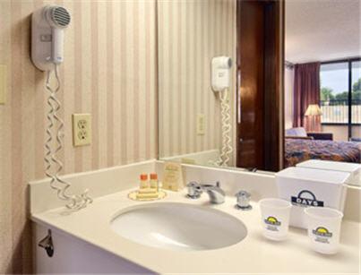 y baño con lavabo y espejo. en Days Inn by Wyndham Raleigh South en Raleigh