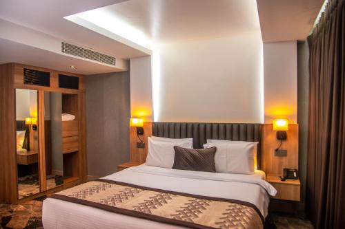 a hotel room with a bed and a mirror at Golden Tulip Lekki in Lekki