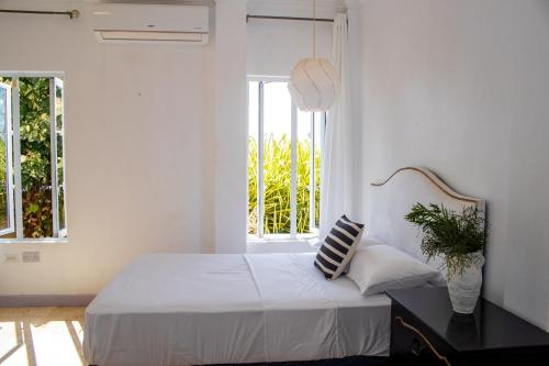 a white bedroom with a bed and a window at La Cresta in Kingstown