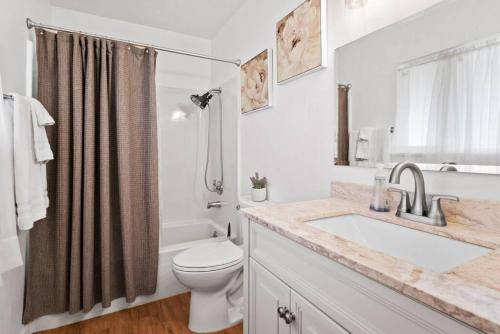 a bathroom with a sink and a toilet and a shower at Oasis House With GATED Pool And Spa in Indio