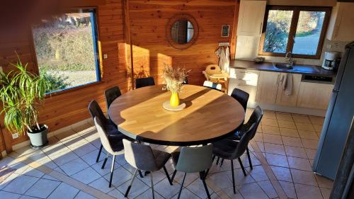 une salle à manger avec une table et des chaises en bois dans l'établissement La maison ronde et ses 2 cahutes, à Monthoiron