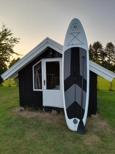 a surfboard is parked in front of a house at Bright summer house close to the beach and water in Holbæk
