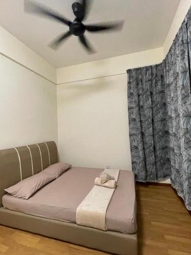 a bedroom with a bed with a ceiling fan at Aurora’s Homestay Sandakan in Sandakan