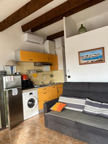 appartement vue mer في كاب داغد: غرفة معيشة مع أريكة ومطبخ