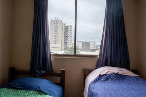 聖地亞哥的住宿－Amplio departamento amoblado a pasos del Movistar Arena, ubicado en Nataniel Cox，一间卧室设有两张床和一个美景窗户。