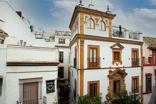 a white building with a clock tower on top of it at Family Luxury Argote in Seville