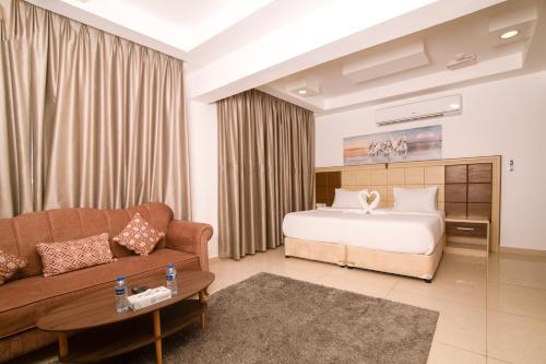 a hotel room with a bed and a couch at Diamond Star Hotel فندق النجمة الماسية in Seeb