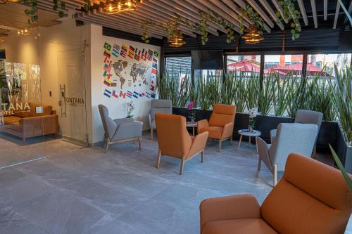 een lobby met stoelen, tafels en planten bij Hotel Fontana Bogotá in Bogota