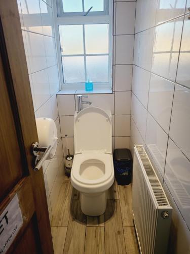 ein kleines Bad mit einem WC und einem Fenster in der Unterkunft QUICK STOP-GATWICK STAY, Family Room-GR1 in Ifield