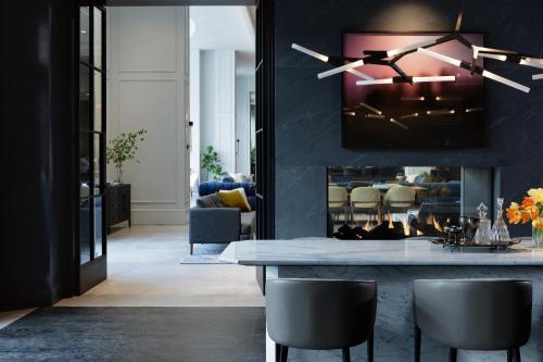 a living room with a table and a fireplace at Kimpton - The Forum Hotel by IHG in Charlottesville