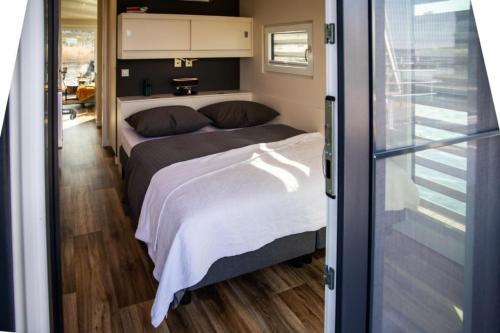 a bedroom with two beds and a sliding glass door at Hausboot Bahama Mama in Klitten