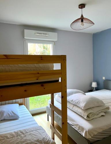 deux lits superposés dans une chambre avec fenêtre dans l'établissement Villa Louise - Appartement Spacieux proche digue avec jardin, à Wimereux
