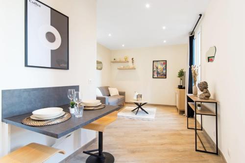 un salon avec une table et un canapé dans l'établissement 2mn Monaco - Hypercentre - Appartement rénové - BN, à Beausoleil