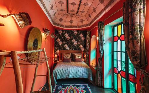 een slaapkamer met oranje muren en een bed en een raam bij Riad OLIVE Privatif 4 Personnes in Marrakesh