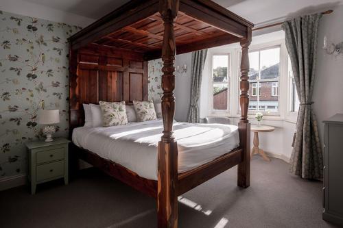 a bedroom with a canopy bed and a window at The Kings Arms Otterton in Budleigh Salterton