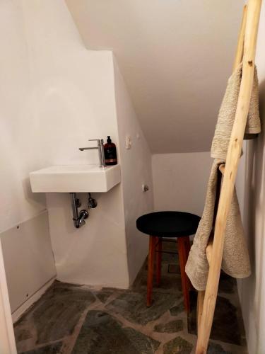 a bathroom with a sink and a stool in a room at Amorgos Elegant Houses, 6 Villas in Amorgos
