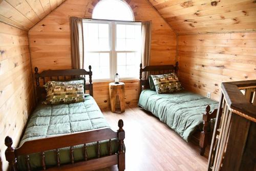 um quarto com 2 camas num chalé de madeira em Treehouse in Maine woods- The Grand Oak em North Lovell