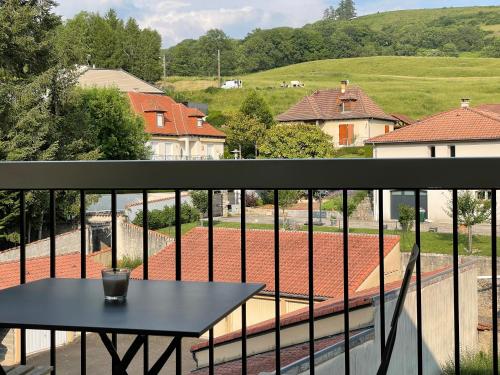a black table on the balcony of a house at Les Jardins du Pont Rouge - Cosy et Calme in Aurillac