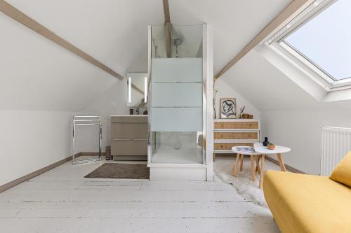 Sala de estar blanca con sofá amarillo y mesa en Maison individuelle dans ancienne ecurie, en Rouen