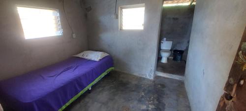 um pequeno quarto com uma cama e um WC em Hostal Pelican em El Gigante
