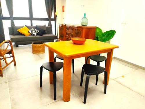 uma mesa de madeira e cadeiras numa sala de estar em Acogedor Loft cerca a estación tren_ calamocha_B em Valência