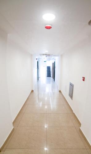 an empty hallway with white walls and a tile floor at Diamond Star Hotel فندق النجمة الماسية in Seeb