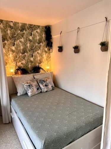 - un lit dans un dortoir avec des plantes sur le mur dans l'établissement Orangers - Bord de mer - Studio cosy 4 personnes, à Cagnes-sur-Mer