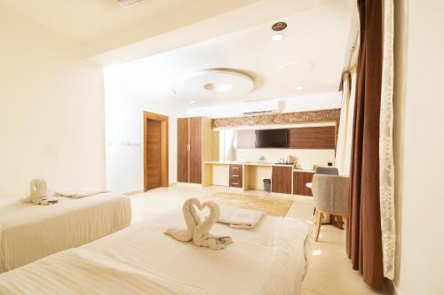 a hotel room with two swans sitting on the beds at Diamond Star Hotel فندق النجمة الماسية in Seeb