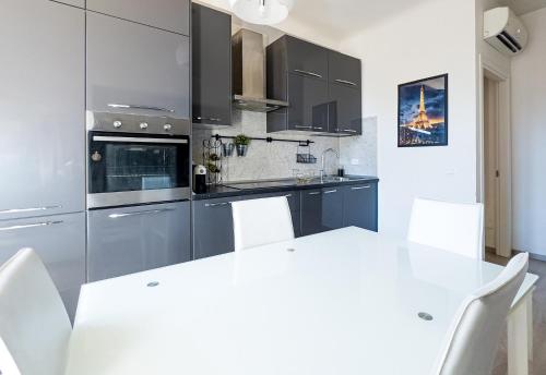 una cucina con elettrodomestici in acciaio inossidabile e tavolo bianco di Luxury Apartment next to the Francescana a Modena