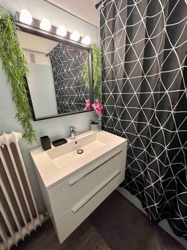 une salle de bain avec un lavabo et un miroir dans l'établissement Orangers - Bord de mer - Studio cosy 4 personnes, à Cagnes-sur-Mer