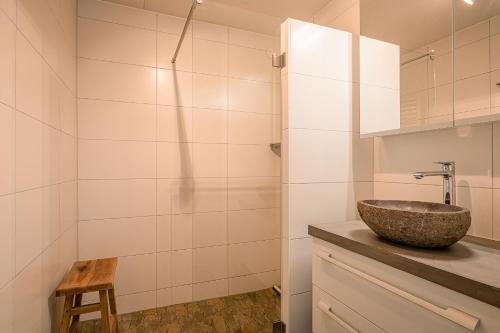 ein Bad mit einem Waschbecken und einer Dusche in der Unterkunft Appartementencomplex Juliana 102 in De Koog