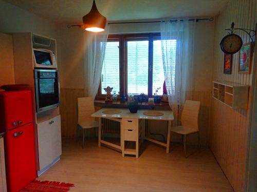 una pequeña cocina con mesa y ventana en Apartmán Eva en Liptovský Svätý Peter
