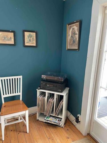 a room with a blue wall and a table and a chair at Mysigt hus för 2 familjer in Västervik