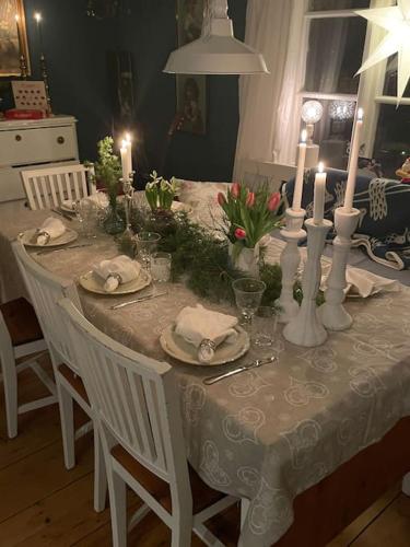 a white table with candles and flowers on it at Mysigt hus för 2 familjer in Västervik