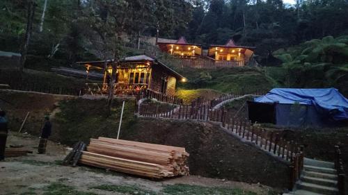 uma casa com luzes à frente à noite em Villa Situ Jampang Campsite em Megamendung