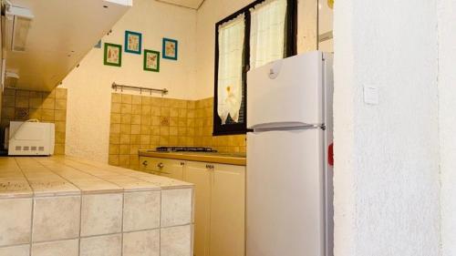une cuisine avec un réfrigérateur blanc dans une pièce dans l'établissement Maison Solane 1 Lumio, à Lumio