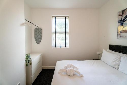Un dormitorio con una cama blanca con un animal de peluche. en Cozy Urban - Retreat Modern 1BR - Free Parking, en Bristol