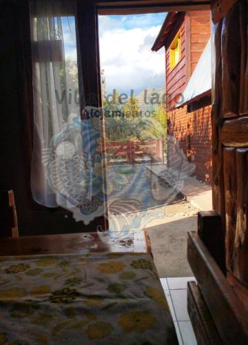 a window in a room with a view of a yard at Villa Del Lago Alojamientos in Lago Puelo